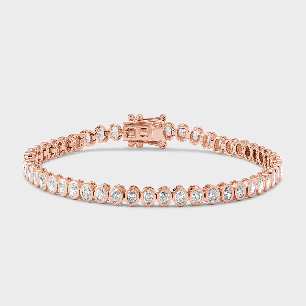 A rose gold tennis bracelet with bezel set, oval shape natural diamonds against a white background. 