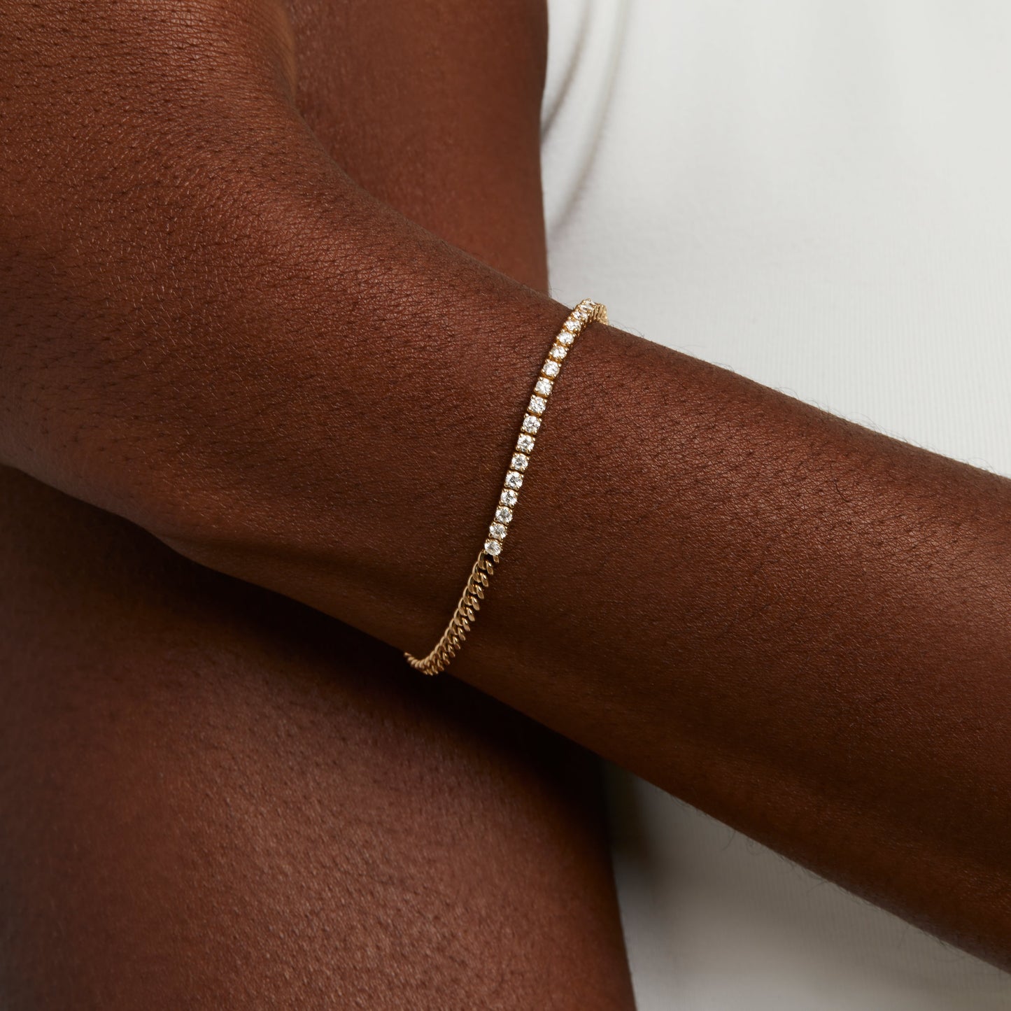 Natural diamond tennis bracelet on yellow gold thick chain bracelet on wrist 