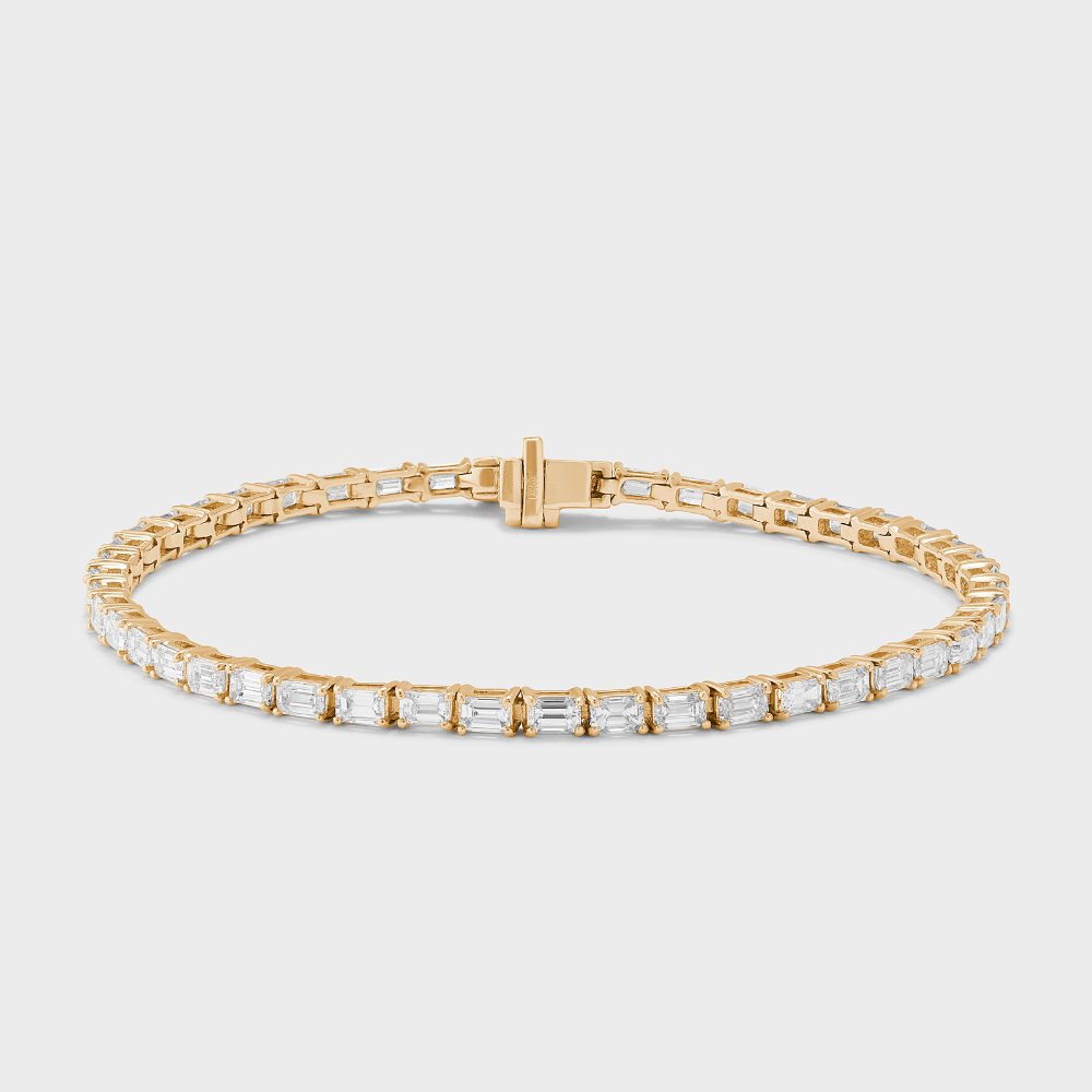 natural diamond tennis bracelet with emerald cut diamonds set east-west in yellow gold