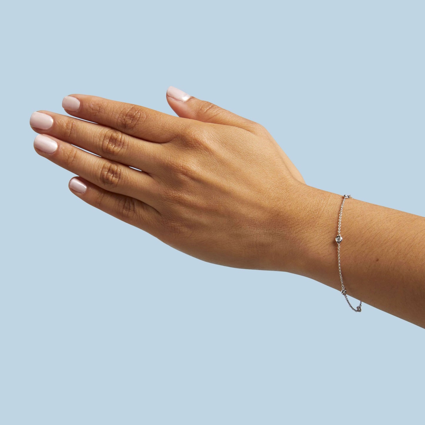 white gold station bracelet with round natural diamonds placed equal distance apart on wrist