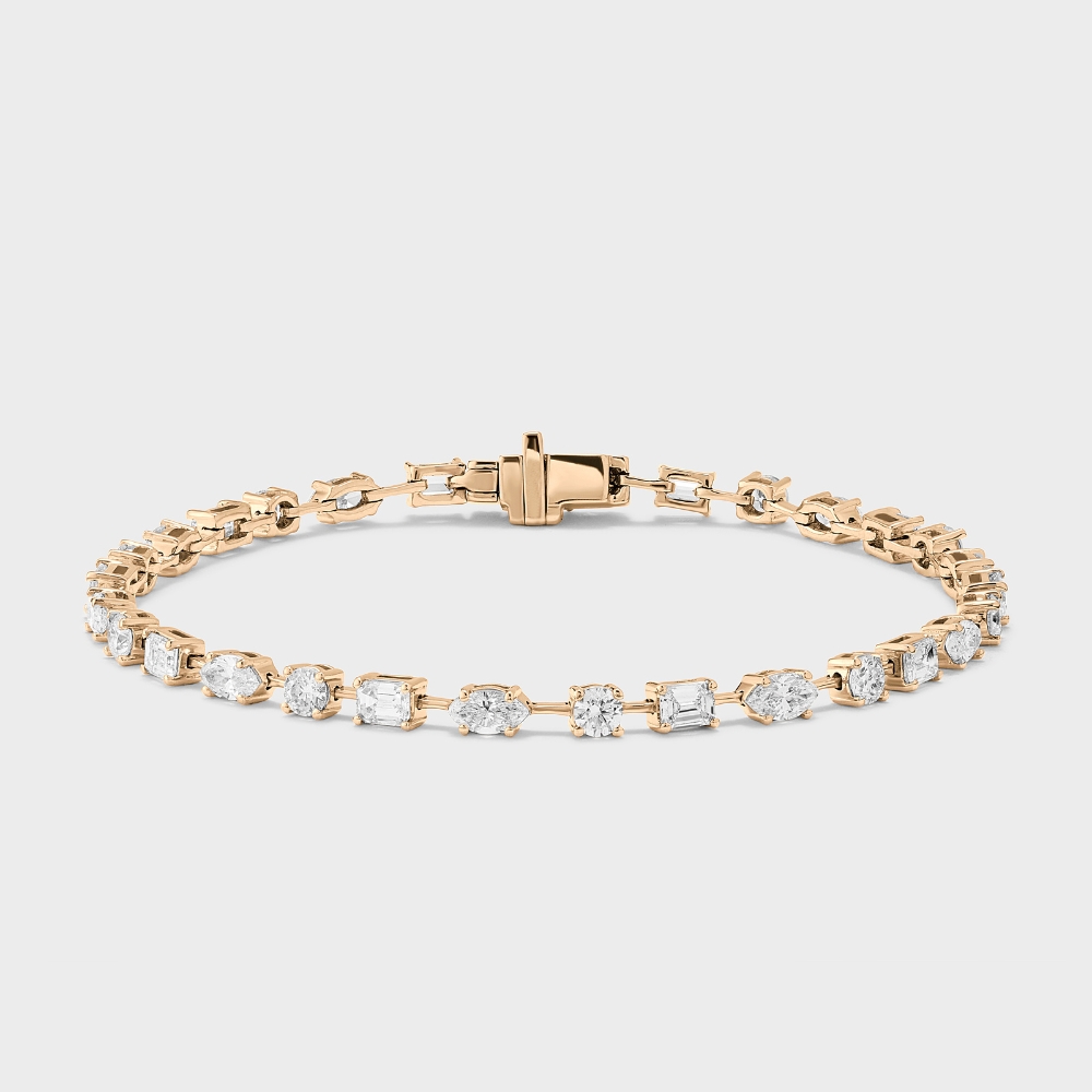 A yellow gold tennis bracelet with mixed fancy shaped natural diamonds.
