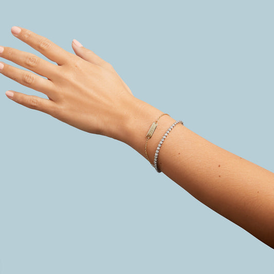 Yellow baby bar bracelet on model wrist. 